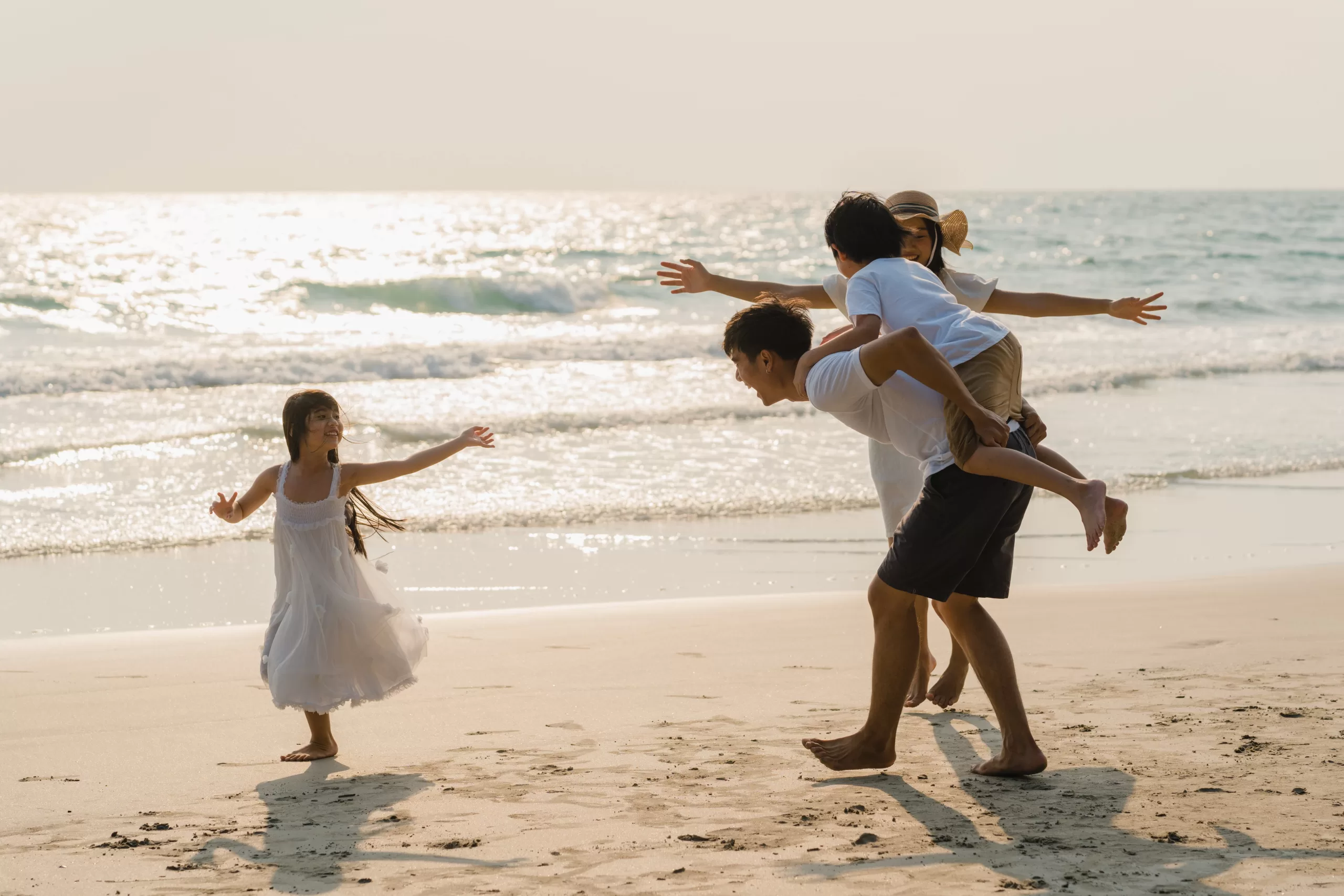 asian young happy family enjoy vacation beach evening dad mom kid relax playing together near sea wh scaled
